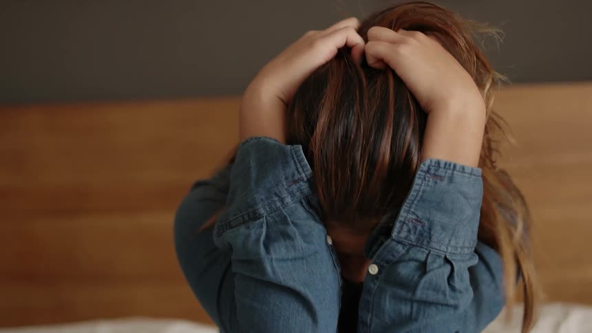 Girl sits with head in her hands