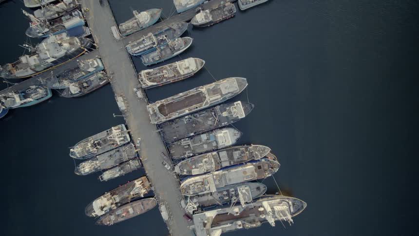 Birds eye view of large commercial fishing trawlers tied down at port