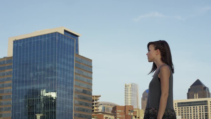 A woman stands in the city during the day