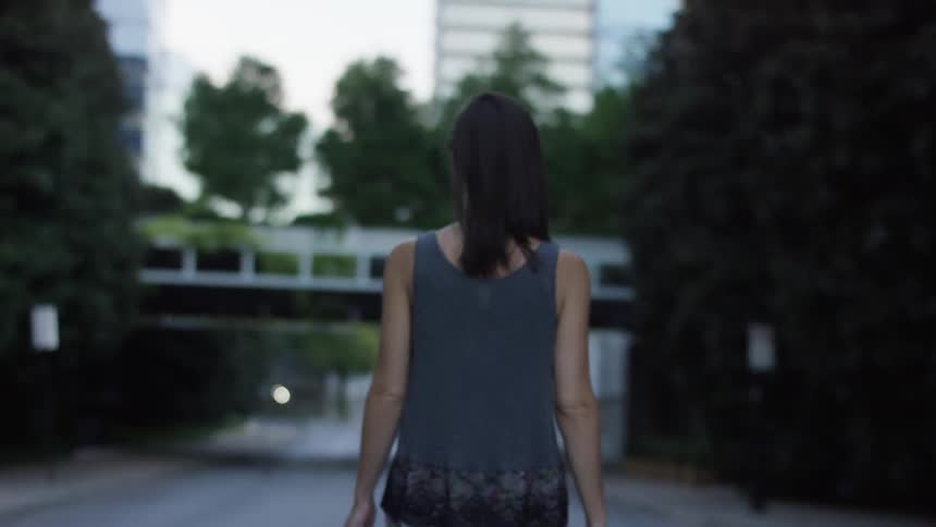 A woman walks down a street in the daytime
