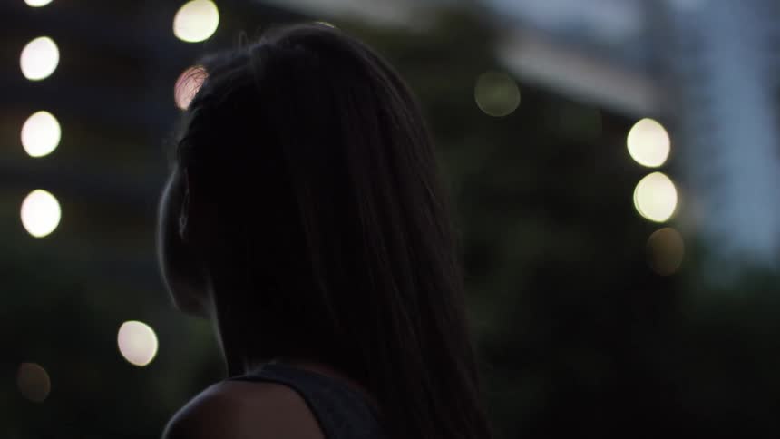A woman looks up at a city building
