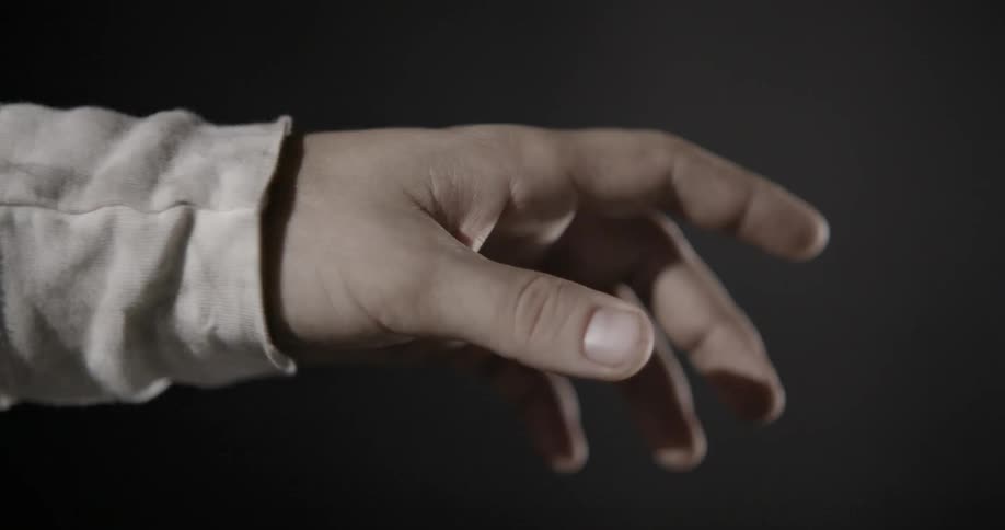 A person reaches their hand towards blinking lights