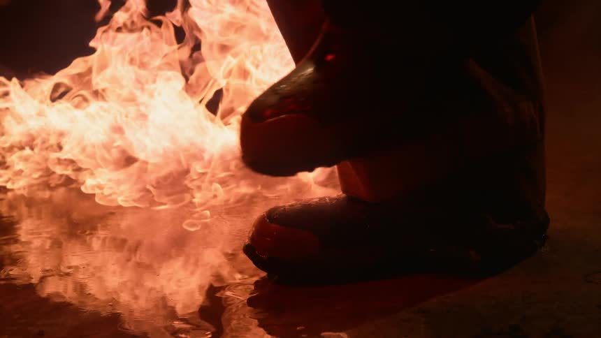A firefighter walks by fire