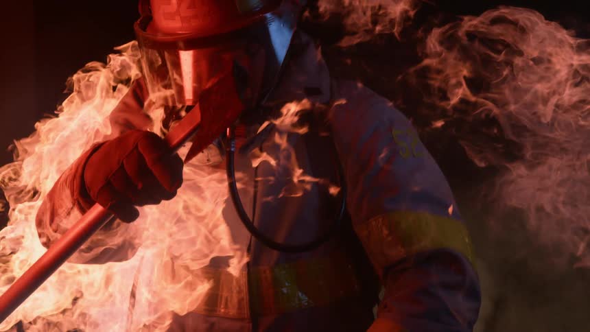 A firefighter walks through the blaze