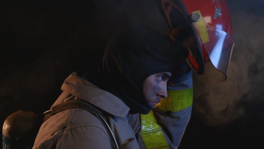 A firefighter puts on his helmet