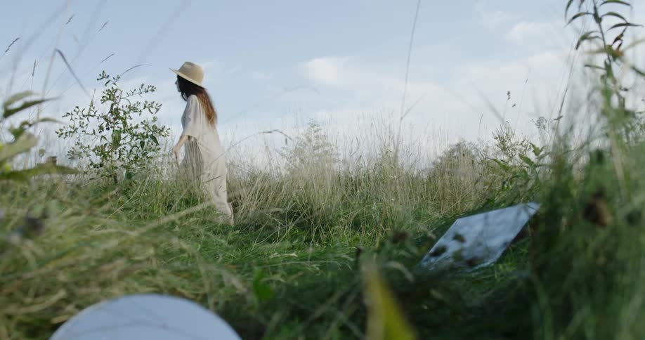 A woman walks through the tall grass