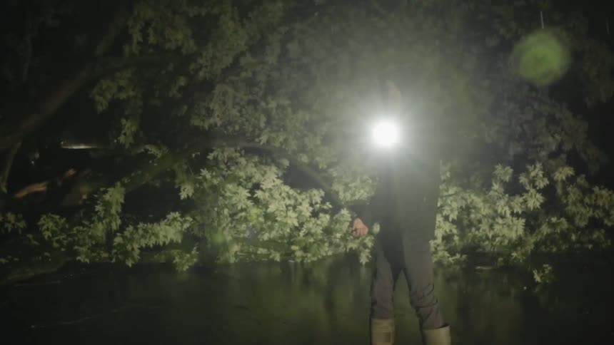 Man walks in the dark with a flashlight