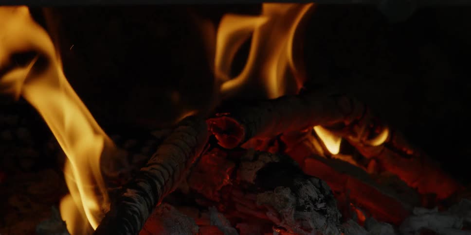 Fire blazes brightly over red glowing embers