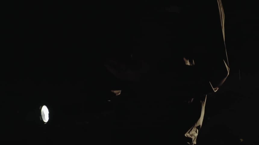 Man stands in the dark and removes something from his pocket