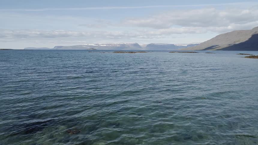 Aerial view of water near mountains in the afternoon