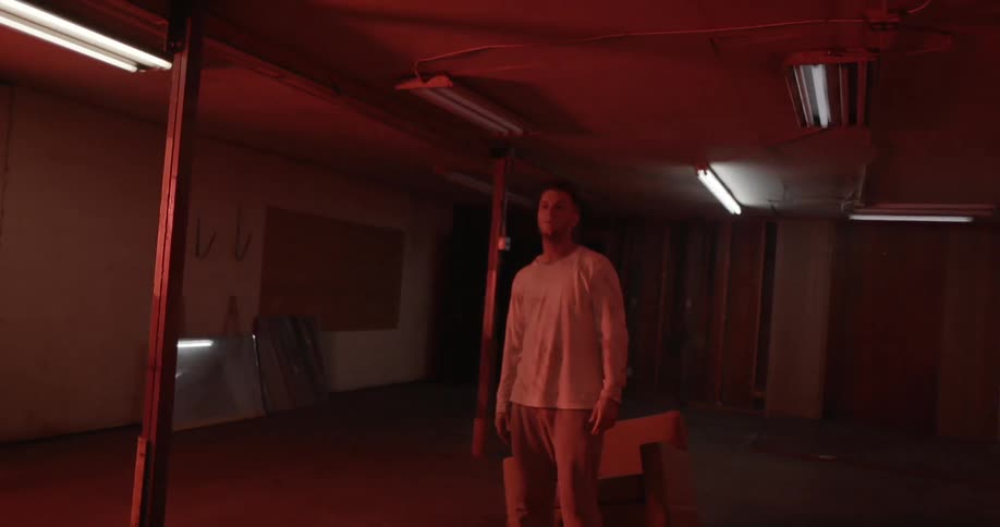Man stands in a red illuminated room and lights flash