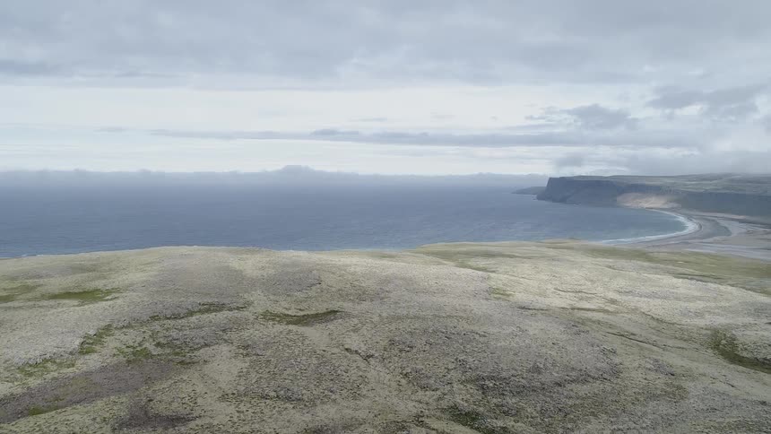 Lake sits next to the land under a cloudy sky