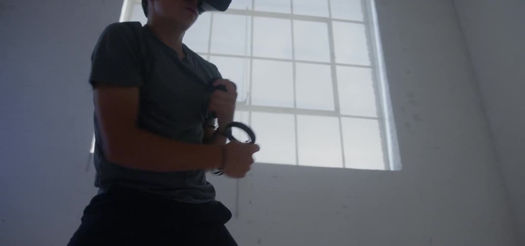 A man is punching forward wearing a virtual reality headset