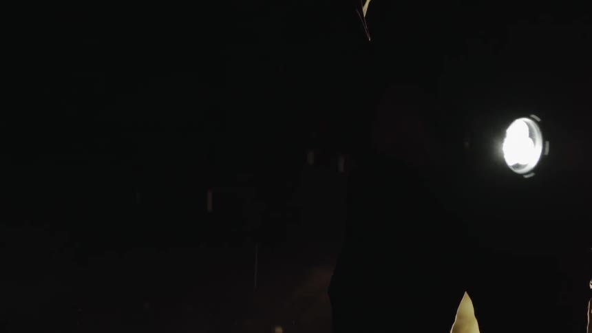 A man moves his flashlight in the rain