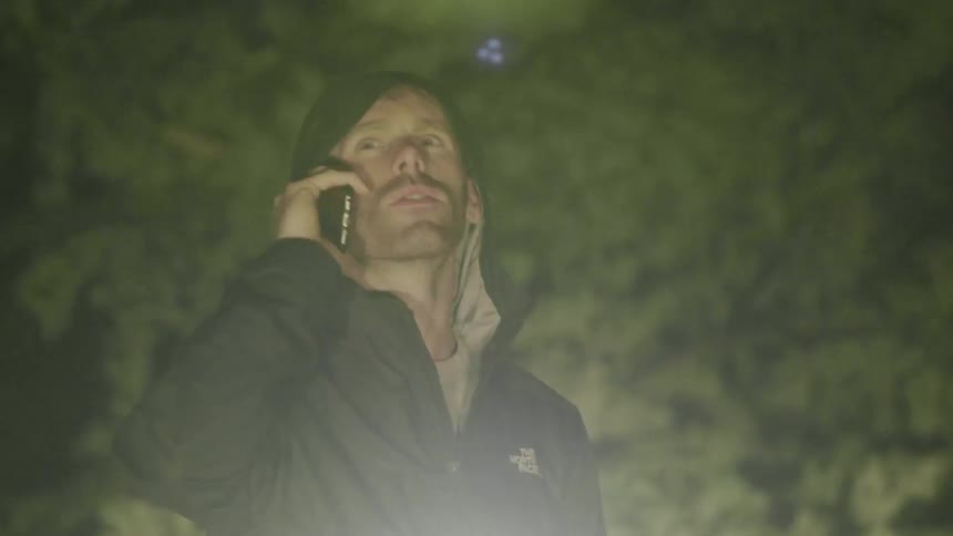 A man talks on the phone at night