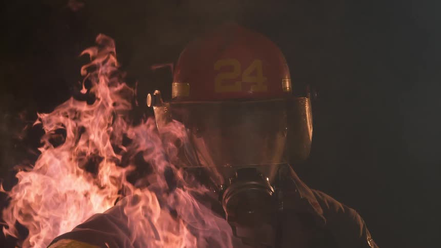 A fire burns around a firefighter