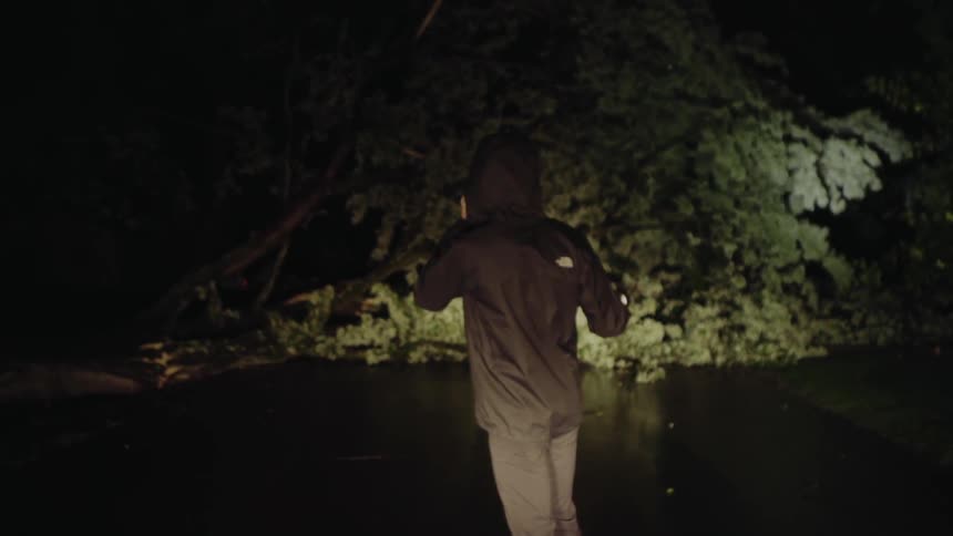 Man standing outside on the phone at night with a flashlight