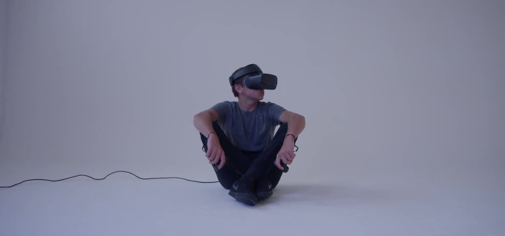 A young man uses a vr headset in an empty room