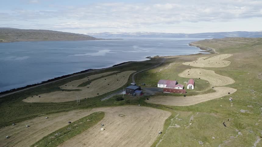 Houses and fields next to a wide river