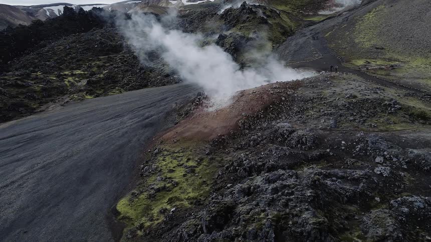 Steam pours out of the ground on a mountainous landscape