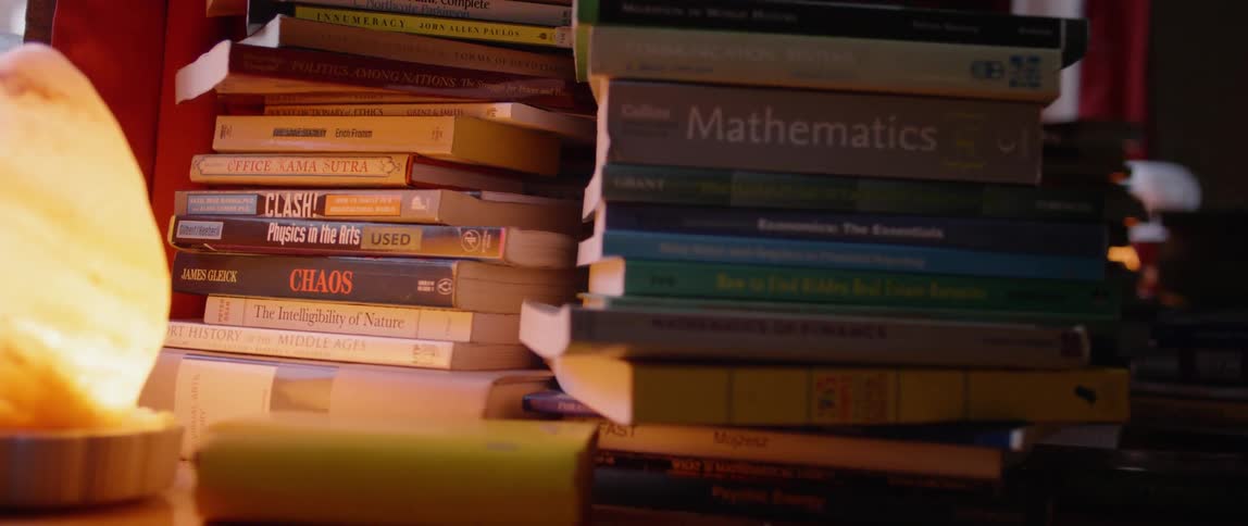 Stacks of books sit as a book falls nearby
