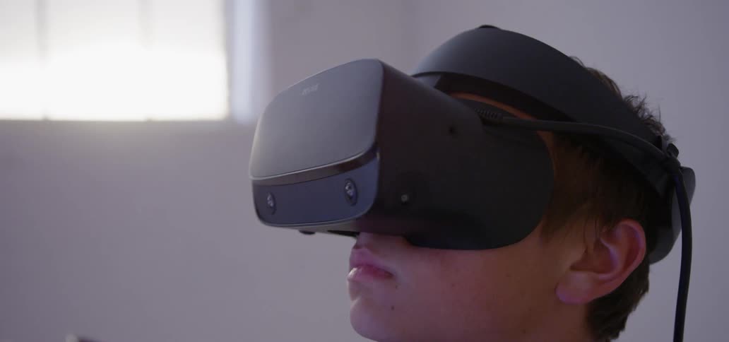 Man wears virtual reality gear as he moves his head