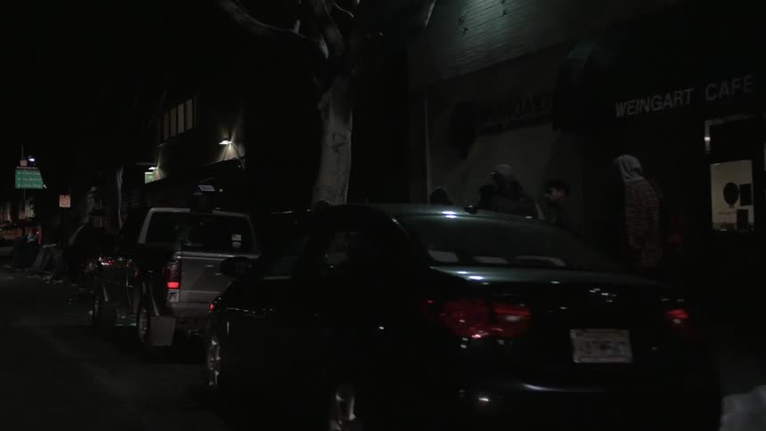 People camp on city sidewalks at night