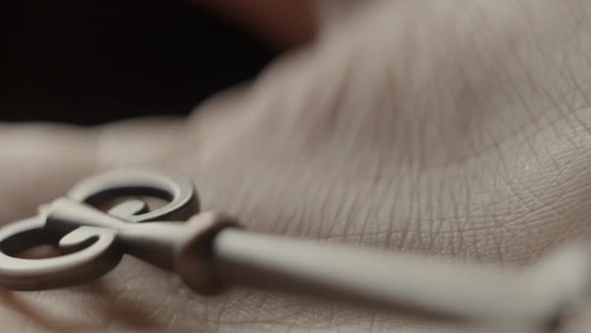 A man holds an old key in his hand