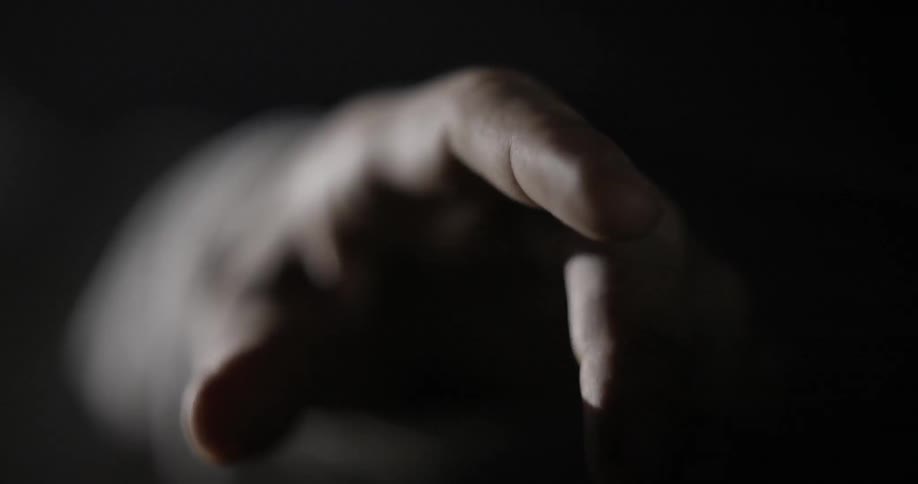 Finger points in a dark room with flashing light