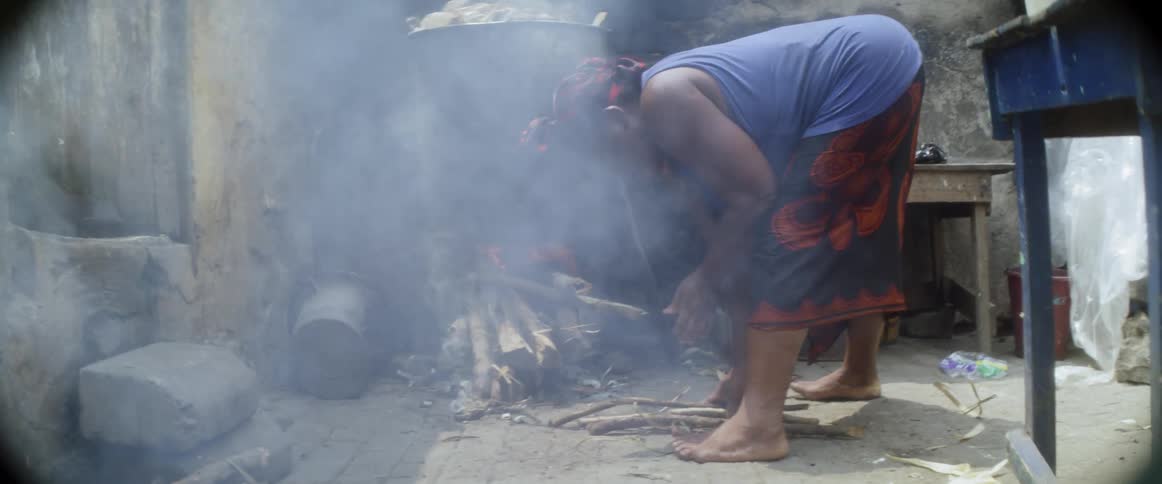 Woman cooking over a wood stove