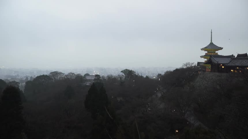 An Asian building and trees on a hilltop on a cloudy day