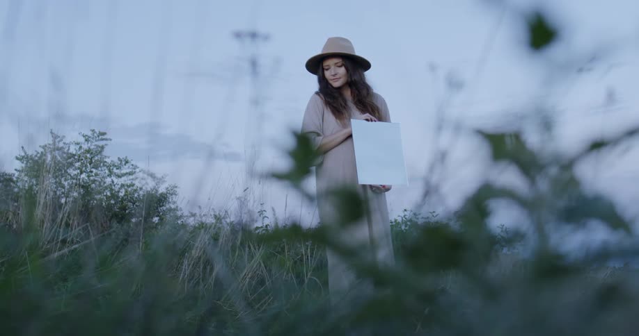 The woman is holding something in the grass