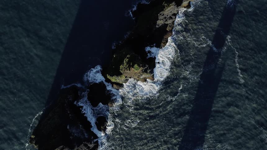 Ocean waves crash into rocks
