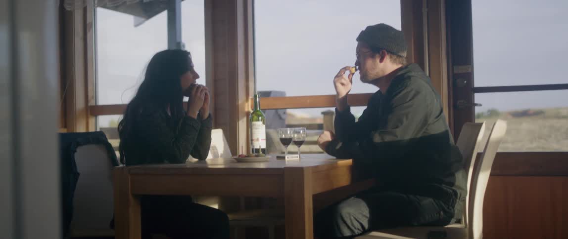 A man and woman eat together at a table