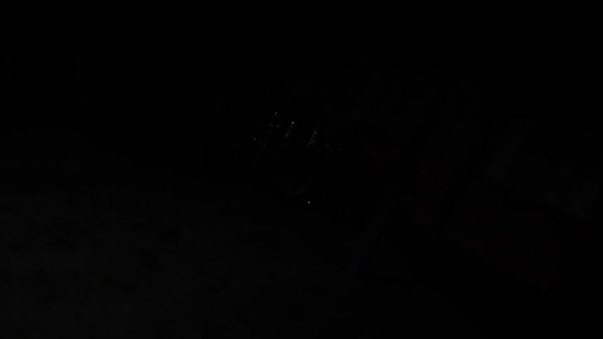 A man plays drums in a room with a strobing light