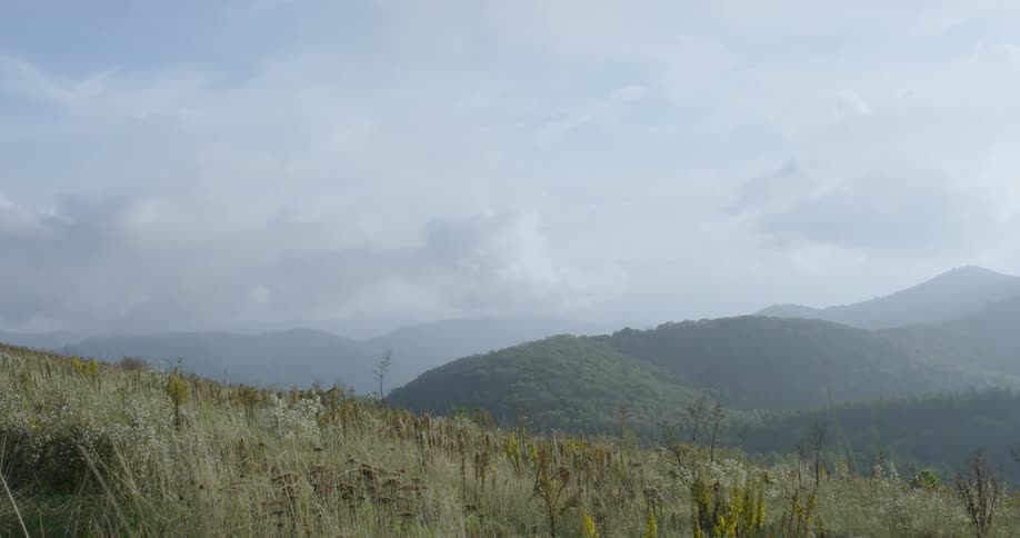 Clouds roll over grasses and hills