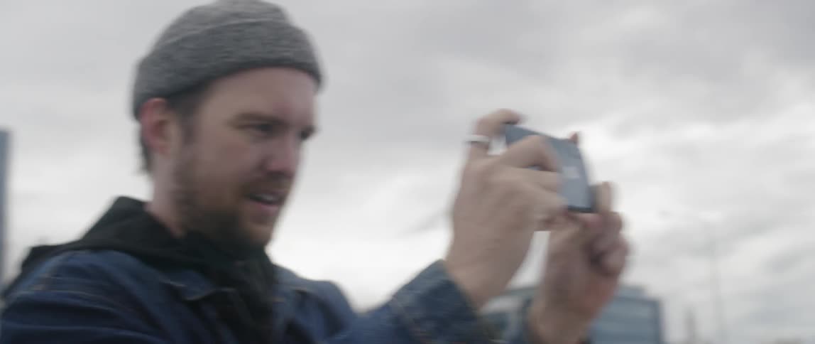 A man takes a photograph of a woman with his phone