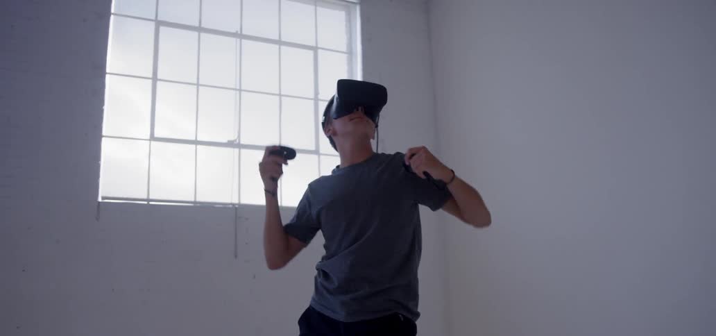 A young man plays while wearing a vr headset