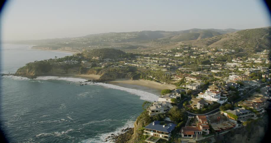 Ocean waves splash to shore next to a city