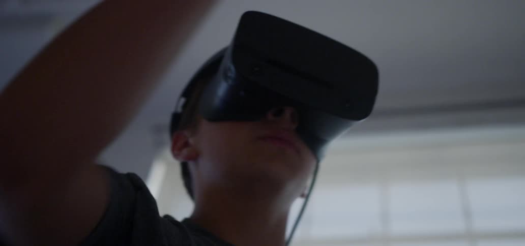 A man is swinging his arms while using a virtual reality headset