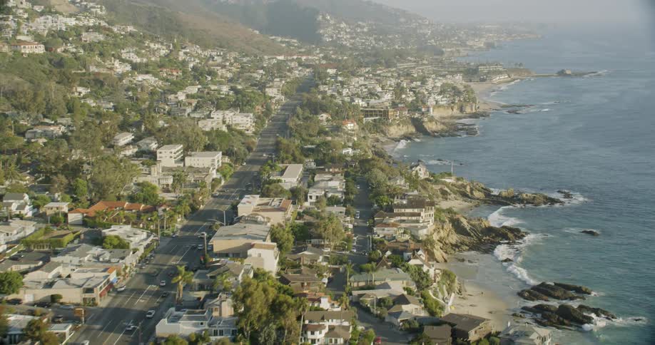 Ocean waves splash to shore next to a city