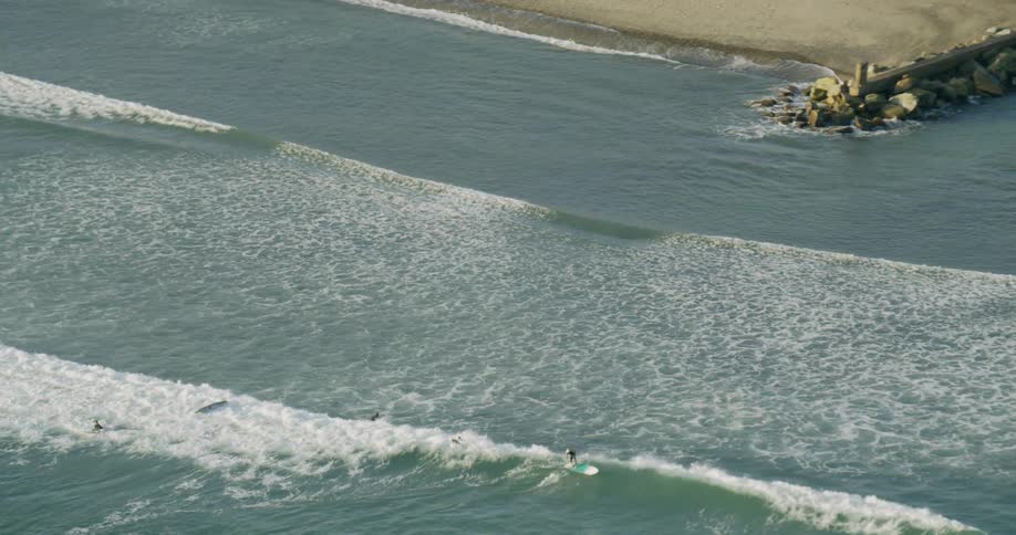 Surfers ride ocean waves on a beach