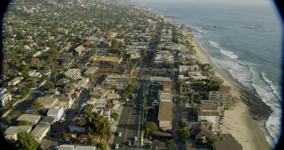 The cars travel down the road in the coastal town