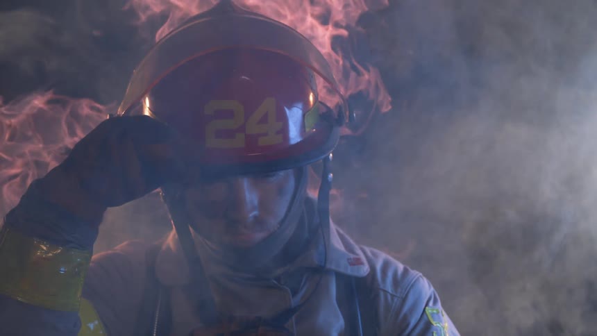 Firefighter stands in front of flames