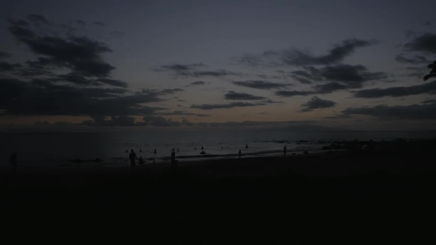 People walking on the beach during sunset