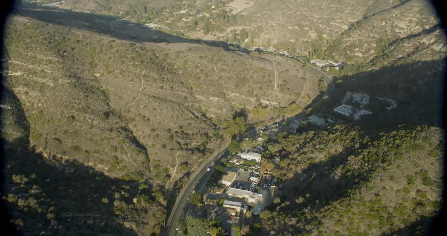Cars drive around the single road around the mountains