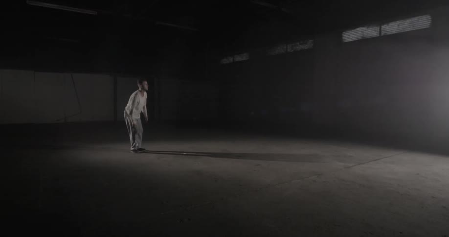 A man stands up in a room with a strobing light