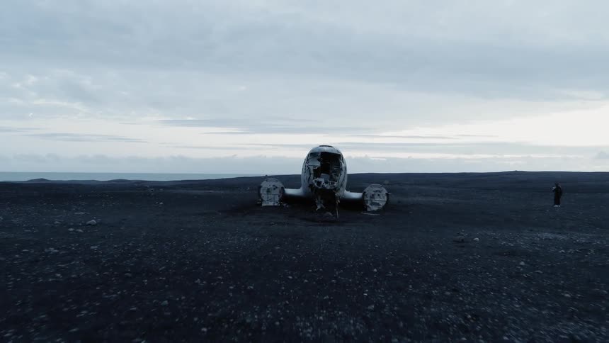 A person stands outside of a plane wreckage