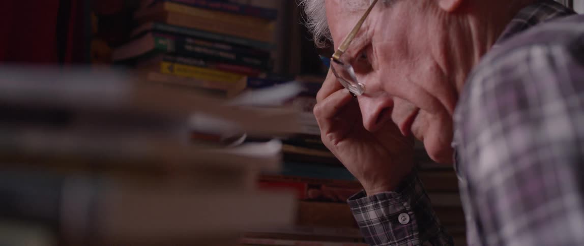 A man leans forward holding his head