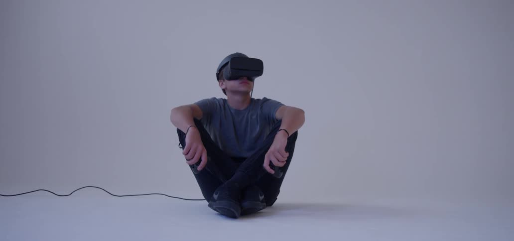 A man sits down while using a vr headset